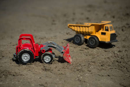 Closeup of construction trucks toys on the beachの写真素材