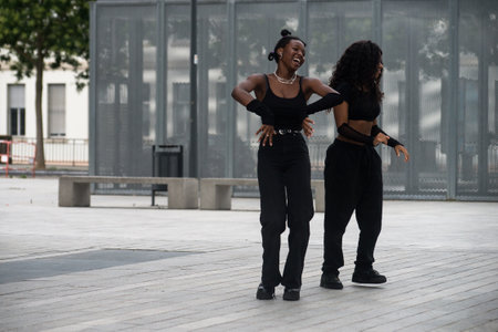 Mulhouse - France - 7 July 2022 - portrait of two young women dancing and smiling in the streetのeditorial素材