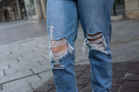 Closeup of destroy blue jeans on young woman in the streetの写真素材