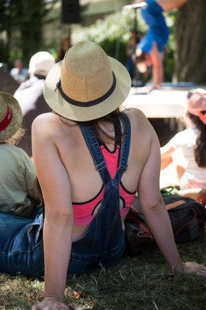 Mulhouse - France - 16 July 2022 - Portrait on back view of young woman wearing a summer hat at the street scene festivalのeditorial素材
