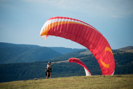 Le grand Ballon - France - 4 August  2022 - View of paraglider preparing her wing before the take off on blue sky backgroundのeditorial素材
