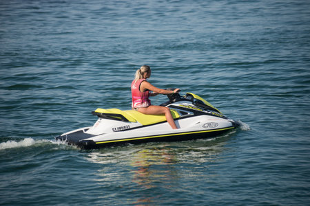 Valras - France - 28 July 2022 - Portrait on back view of young woman sitting on jet ski in the waterのeditorial素材