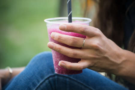 Closeup of pilled ice in hand on young woman in a public garden