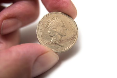Closeup of the queen Elisabeth II  on british coin in hand on white background