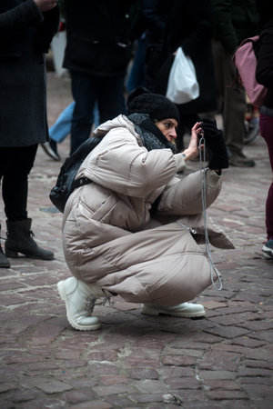 Colmar - France - 9 december 2022 - portrait of tourist taking a photo with her smartphone in the street at the christmas marketのeditorial素材