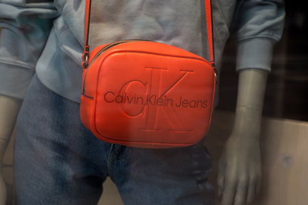 Mulhouse - France - 10 February 2023 - closeup of orange color handbag by calvin klein in a fashion...