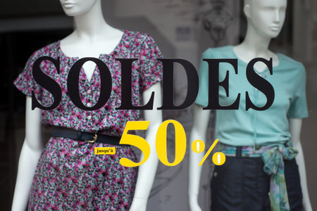 closeup of discount sign SOLDES up to 50% in french, the translation of (sales until 50%) on window...