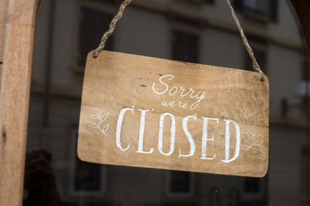Closeup of sorry we are closed panel in a fashion store entry in the street