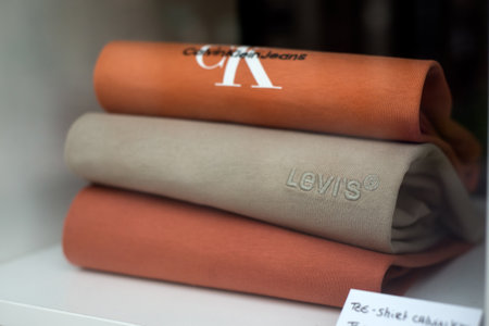 Mulhouse - France - 14 September 2023 - Closeup of calvin Klein and levi's strauss pullover pile in a fashion store showroomのeditorial素材