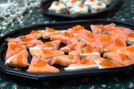 Closeup of appetizers toast with salmon and lumpfish roe in a black plate lumpfish roeの写真素材