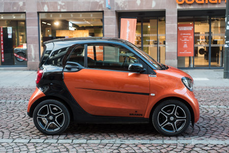 Strasbourg - France - 3 February 2024 - Profile view of orange and black smart car parked in the streetのeditorial素材