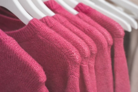closeup of colorful woolen pullover on hangers in a woman fashion store showroomの写真素材