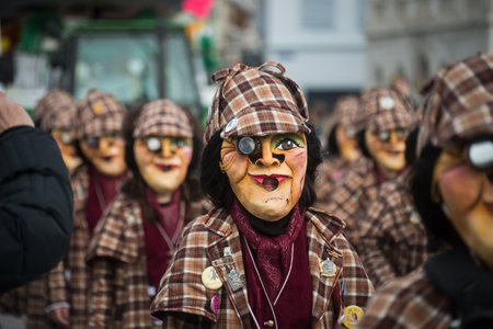 Basel - Switzerland - 21 February 2024 - portrait of masked people wearing traditional costume playing music parading in the streetのeditorial素材