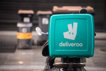 Mulhouse - France - 25 february 2024 - Closeup of deliveroo logo on blue plastic backpack on motorcycle parked  in the streetのeditorial素材