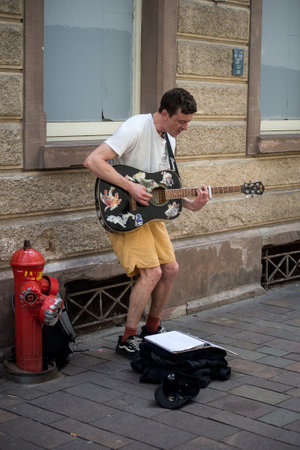 Mulhouse - France - 10 April 2024 - portrait of street musician playing guitar in the streetのeditorial素材