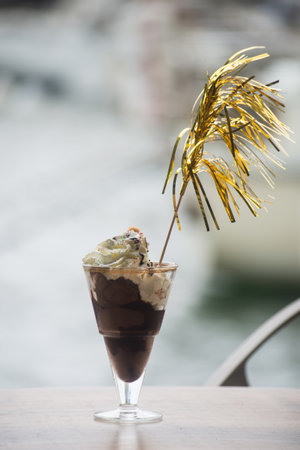 Closeup of chocolate ice cream in a glass at the restaurant terrace at the harborの写真素材