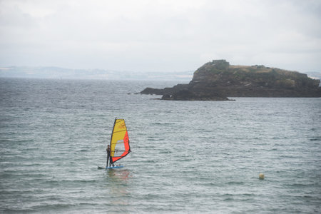 Douarnenez - France - 12 July 2024 - portrait of young girl playing windsurf in the ocean on cloudy sky backgroundのeditorial素材