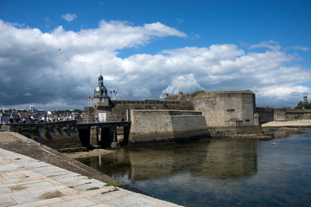 concarneau - France - 11 July 2024 -   view of the old closed city fortifications in the harbor on cloudy sky backgroundのeditorial素材