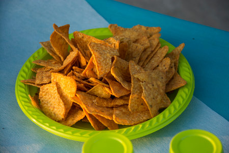 Closeup of potatoes chips in a plastic plate at the party buffetの写真素材