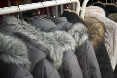 closeup of winter coat with fur on hanger in fashion storeの写真素材