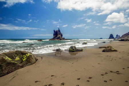 Steep high lava rock cliffs in Los Gigantes, Tenerife. Blue sea horizon, natural sky background.の写真素材
