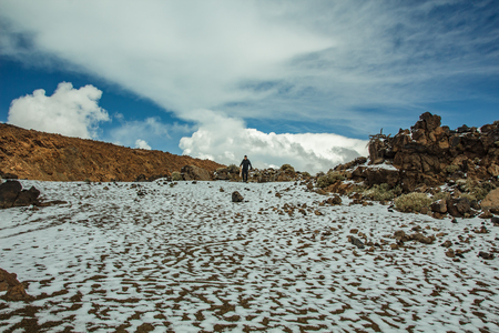 Mountain Teide with white snow spots, partly covered by the clouds. Bright blue sky. Teide National Park, Tenerife, Canary Islands, Spain.の写真素材