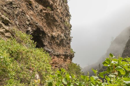 An old aqueduct now used as an adventure hiking trail Guimar valley. Trail in the fog through the mysterious mountains and caves. Tenerife, Spain.の写真素材