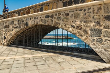 Puerto de la Cruz, Tenerife, Spain - July 10, 2019: . The Old port of town is a popular tourist attraction and favorite place for the locals. We see the harbor, walking and bathing people.の写真素材