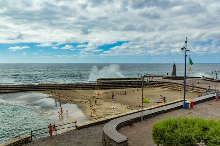 Bajamar, Tenerife, Spain, 22, June, 2015: View from the coast of the Punta Larga lighthouse. Sand beach near natural sea water pools. Favorite vacation spot for locals and tourists.のeditorial素材