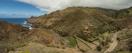 One of the tight turns of a narrow rural road in the mountains of Parque Natural Majona. View of Playa De Caleta the north-eastern part of La Gomera island. Canary Islands, Spain.の写真素材