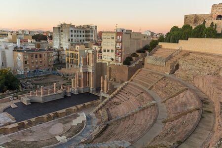 Aerial panoramic view of port city Cartagena in Spain with famous roman amphitheater. Beautiful sunset over the mountains. Wide angle lens panorama.の写真素材