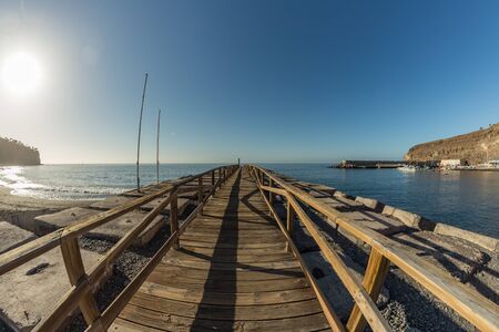 Early morning of quiet warm, sunny weather in the beach and harbor of Playa de Santiago. Panoramic, fisheye lens, wide angle view. Gomera, Canary Islands, Spain.の写真素材