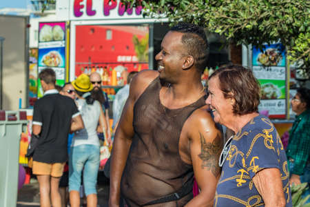 SANTA CRUZ DE TENERIFE, SPAIN - FEBRUARY 25, 2020: Around the Coso parade - along the Avenida de Anaga, official end of Carnival. Amazing warm evening, joyful people in carnival costumes have fun.のeditorial素材