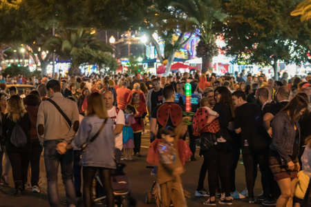 SANTA CRUZ DE TENERIFE, SPAIN - FEBRUARY 25, 2020: Around the Coso parade - along the Avenida de Anaga, official end of Carnival. Amazing warm evening, joyful people in carnival costumes have fun.のeditorial素材