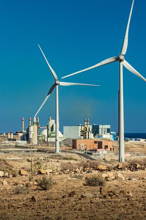 Thermal power station and a series of wind turbines near the sea coast. Wind farm eco field. Eolic...