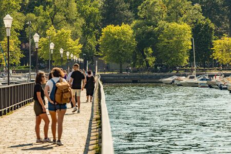Como, ITALY - August 4, 2019: Local people and tourists on the promenade along the lake in the center of beautiful Italian Como city. Warm sunny summer day in very popular holiday destinationの写真素材
