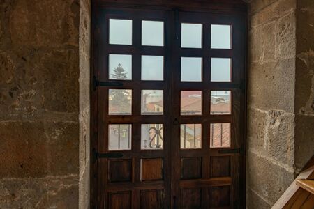 Top view through the slatted window from the high tower of the church. Outside the window are low...