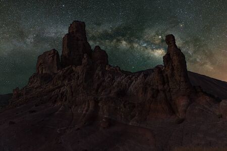 Milky Way in the spring sky above the red narrow volcanc rocks Teide National Park near Observatory. Jupiter is sparkling surrounded by star clusters and nebulae. Brihgt stars in the night sky.の写真素材