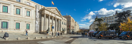 MADRID, SPAIN - DECEMBER 13, 2018: Congreso De Los Diputados in the Palace of the Parliament, or Plaza de las Cortes. Police cars parked in front of the Main entrance. Super wide angle panorama.のeditorial素材