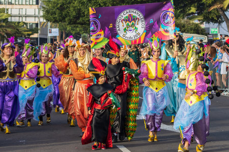 SANTA CRUZ DE TENERIFE, SPAIN - FEBRUARY 13, 2024: The Coso parade, Cavalcada - along the Avenida de Anaga, official end of Carnival. Amazing warm evening, joyful people in carnival costumes have fun.のeditorial素材
