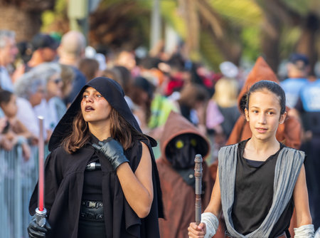 SANTA CRUZ DE TENERIFE, SPAIN - FEBRUARY 13, 2024: The Coso parade, Cavalcada - along the Avenida de Anaga, official end of Carnival. Amazing warm evening, joyful people in carnival costumes have fun.のeditorial素材