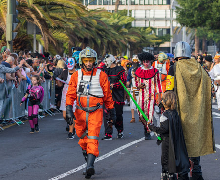 SANTA CRUZ DE TENERIFE, SPAIN - FEBRUARY 13, 2024: The Coso parade, Cavalcada - along the Avenida de Anaga, official end of Carnival. Amazing warm evening, joyful people in carnival costumes have fun.のeditorial素材