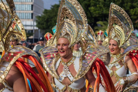 SANTA CRUZ DE TENERIFE, SPAIN - FEBRUARY 13, 2024: The Coso parade, Cavalcada - along the Avenida de Anaga, official end of Carnival. Amazing warm evening, joyful people in carnival costumes have fun.のeditorial素材