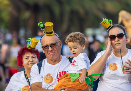 SANTA CRUZ DE TENERIFE, SPAIN - FEBRUARY 13, 2024: The Coso parade, Cavalcada - along the Avenida de Anaga, official end of Carnival. Amazing warm evening, joyful people in carnival costumes have fun.のeditorial素材