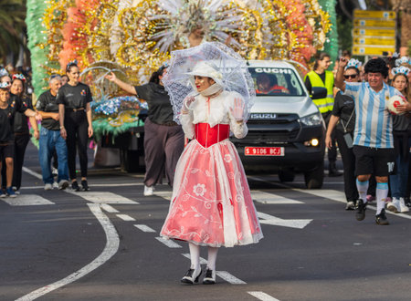 SANTA CRUZ DE TENERIFE, SPAIN - FEBRUARY 13, 2024: The Coso parade, Cavalcada - along the Avenida de Anaga, official end of Carnival. Amazing warm evening, joyful people in carnival costumes have fun.のeditorial素材