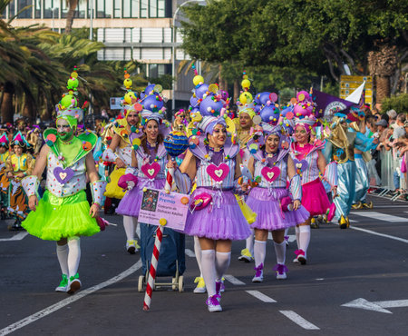 SANTA CRUZ DE TENERIFE, SPAIN - FEBRUARY 13, 2024: The Coso parade, Cavalcada - along the Avenida de Anaga, official end of Carnival. Amazing warm evening, joyful people in carnival costumes have fun.のeditorial素材