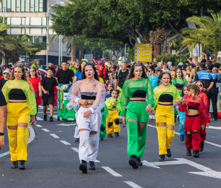 SANTA CRUZ DE TENERIFE, SPAIN - FEBRUARY 13, 2024: The Coso parade, Cavalcada - along the Avenida de Anaga, official end of Carnival. Amazing warm evening, joyful people in carnival costumes have fun.のeditorial素材