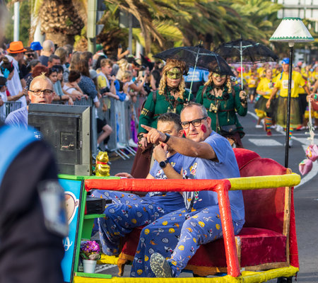 SANTA CRUZ DE TENERIFE, SPAIN - FEBRUARY 13, 2024: The Coso parade, Cavalcada - along the Avenida de Anaga, official end of Carnival. Amazing warm evening, joyful people in carnival costumes have fun.のeditorial素材