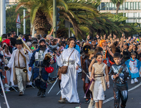 SANTA CRUZ DE TENERIFE, SPAIN - FEBRUARY 13, 2024: The Coso parade, Cavalcada - along the Avenida de Anaga, official end of Carnival. Amazing warm evening, joyful people in carnival costumes have fun.のeditorial素材