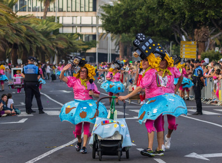 SANTA CRUZ DE TENERIFE, SPAIN - FEBRUARY 13, 2024: The Coso parade, Cavalcada - along the Avenida de Anaga, official end of Carnival. Amazing warm evening, joyful people in carnival costumes have fun.のeditorial素材
